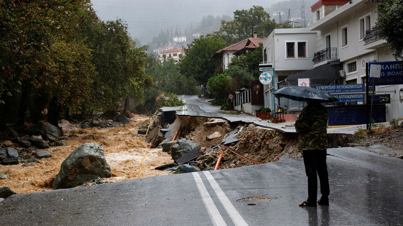 A person stands on a road which collapsed due to the impact of storm Daniel, near a nursing home in the city of Volos, Greece, September 6, 2023. REUTERS/Louisa Gouliamaki