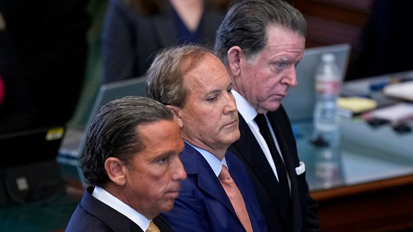 Texas state Attorney General Ken Paxton, center, stands between his attorneys Tony Buzbee, front, and Dan Cogdell, rear, as the articles of his impeachment are read during the his impeachment trial in the Senate Chamber at the Texas Capitol, Tuesday, Sept. 5, 2023, in Austin, Texas.