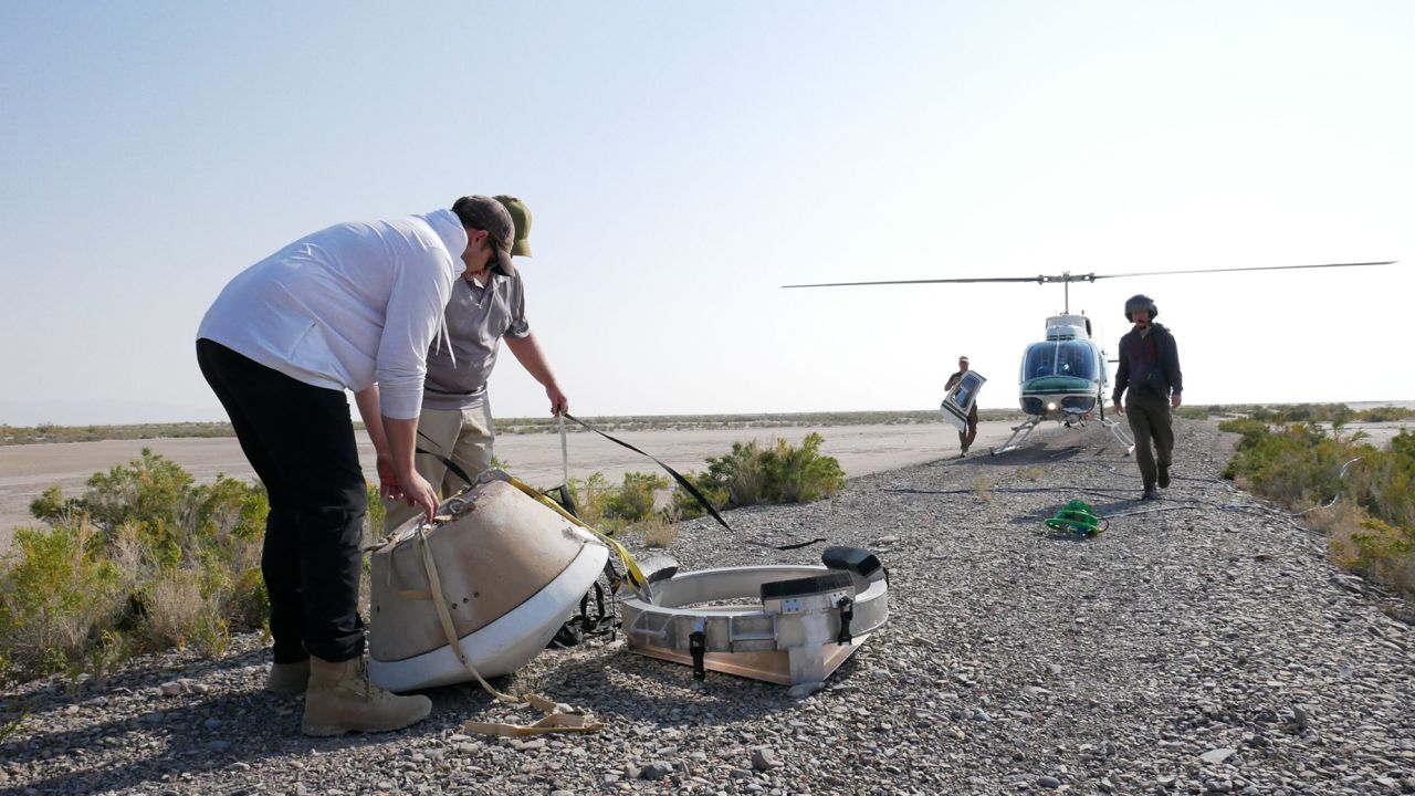 On Aug. 30, 2023, the OSIRIS-REx team held their final rehearsal before a sample of asteroid Bennu lands on Earth on Sept. 24. Pictured here are capsule recovery team members of from OSIRIS-REx and from the military packing up a mock capsule. The capsule had just been delivered to this location by helicopter. About 30 minutes beforehand, the helicopter had dropped the capsule from 7,000 feet above the surface of the Department of Defense's Utah Test and Training Range. The capsule descended by parachute to the ground, while infrared, radar, and optical instruments on the ground and on airplanes practiced tracking its descent, as they will do when the real capsule lands next month.
