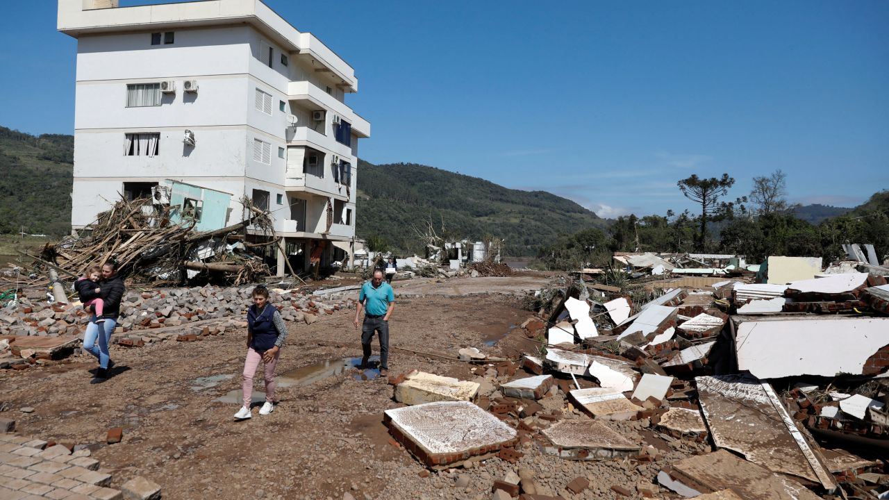 People walk in front of a damaged building in Mucum, Rio Grande do Sul, Brazil, September 6, 2023.