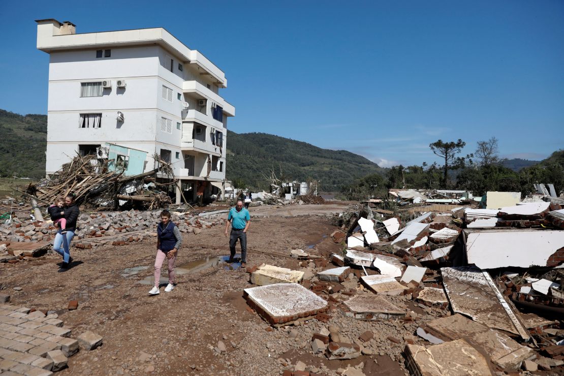 People walk in front of a damaged building in Mucum, Rio Grande do Sul, Brazil, September 6, 2023. 