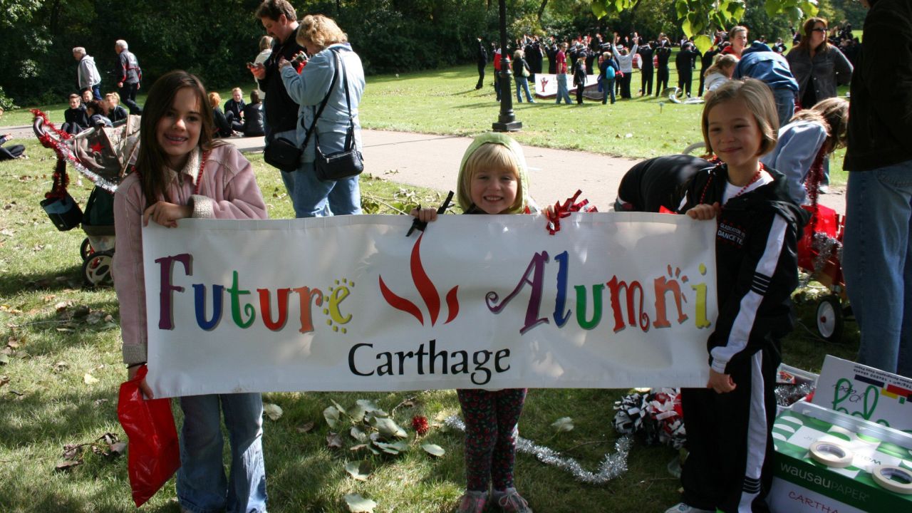 A childhood picture of Mia Carter, center, holding a Carthage banner.