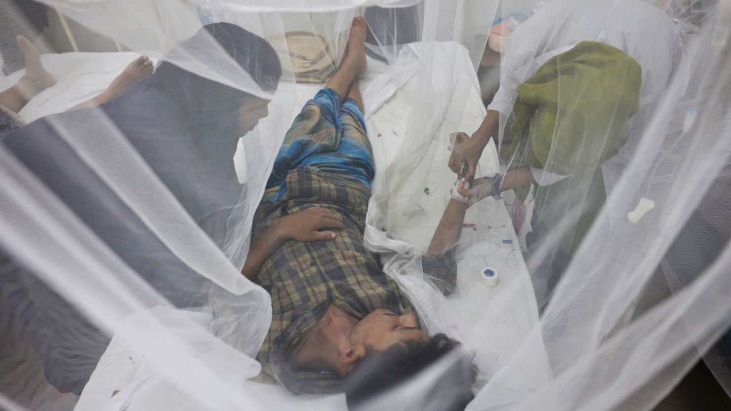A dengue-infected patient receives treatment through mosquito nets in the Shaheed Suhrawardy Medical College and Hospital in Dhaka, Bangladesh, on July 26.