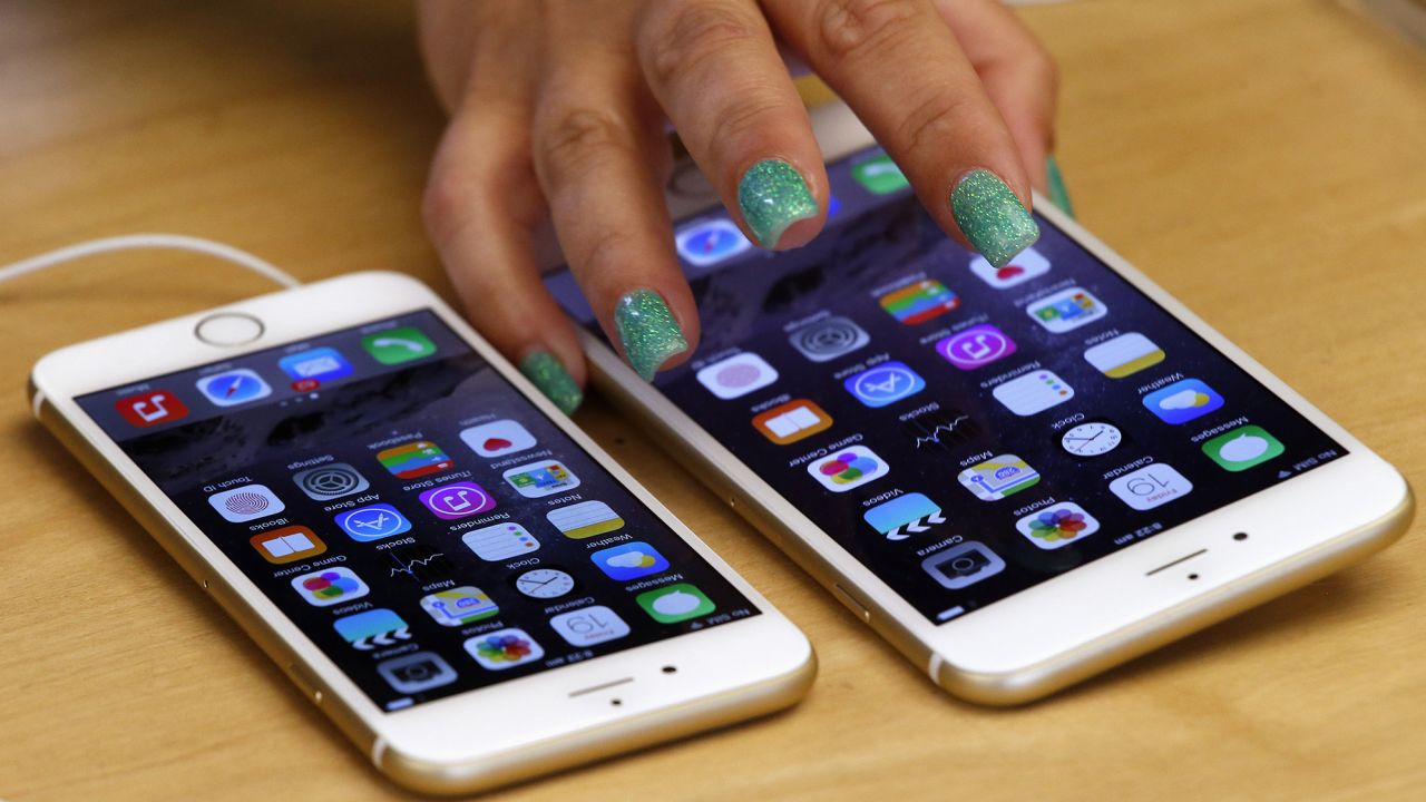 A woman touches an iPhone 6 Plus as it sits next to an iPhone 6 after they went on sale at the Apple Store in Sydney on September 19, 2014. 