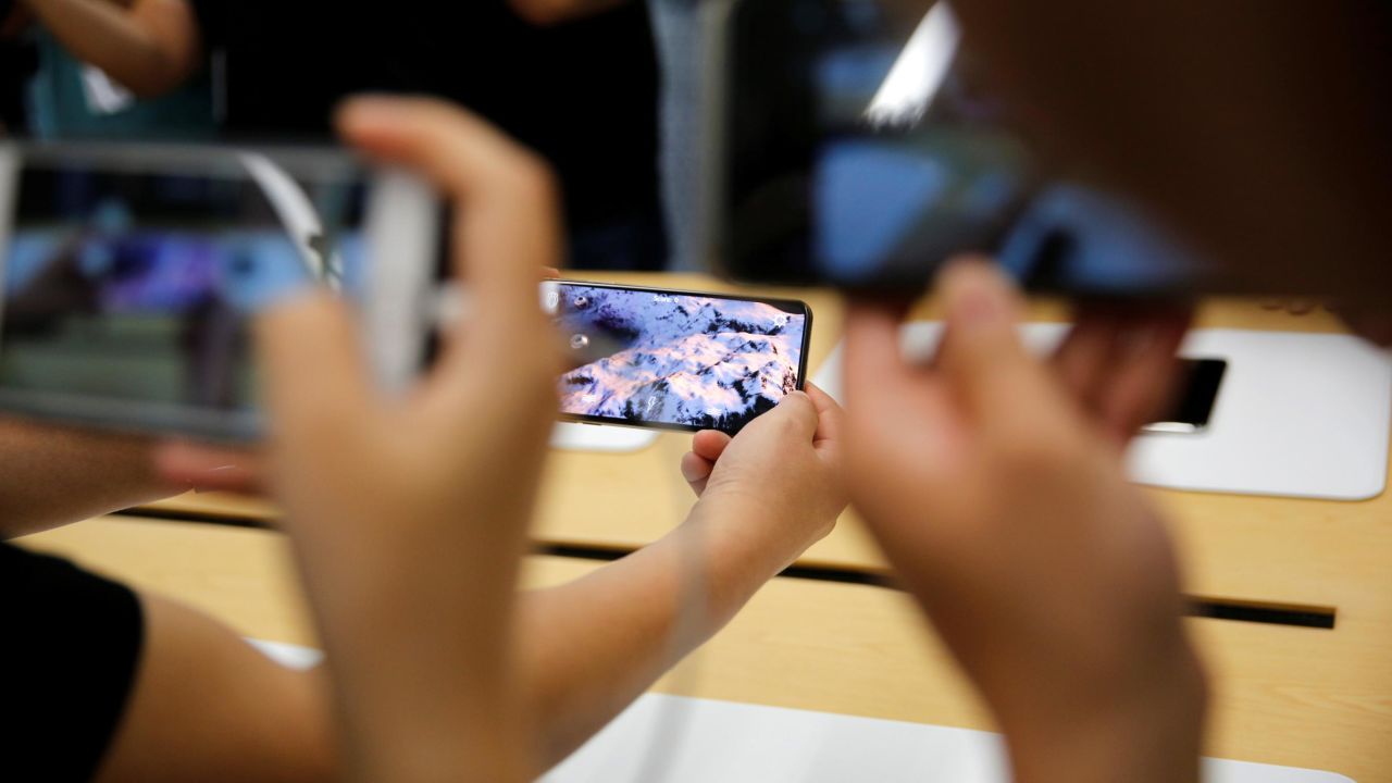 People handle the new Apple iPhone XS and iPhone XS Max during a media tour at an Apple office in Shanghai, China, on September 21, 2018. 