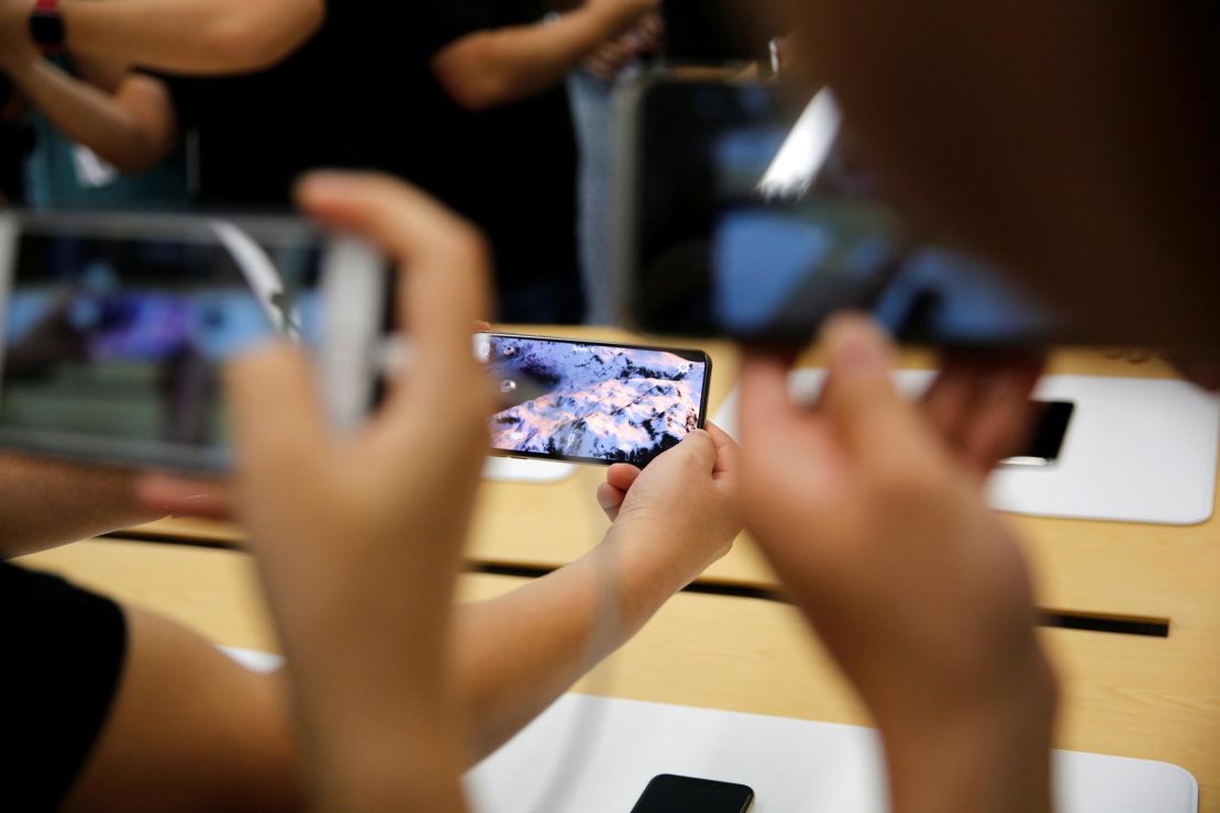 People handle the new Apple iPhone XS and iPhone XS Max during a media tour at an Apple office in Shanghai, China, on September 21, 2018. 