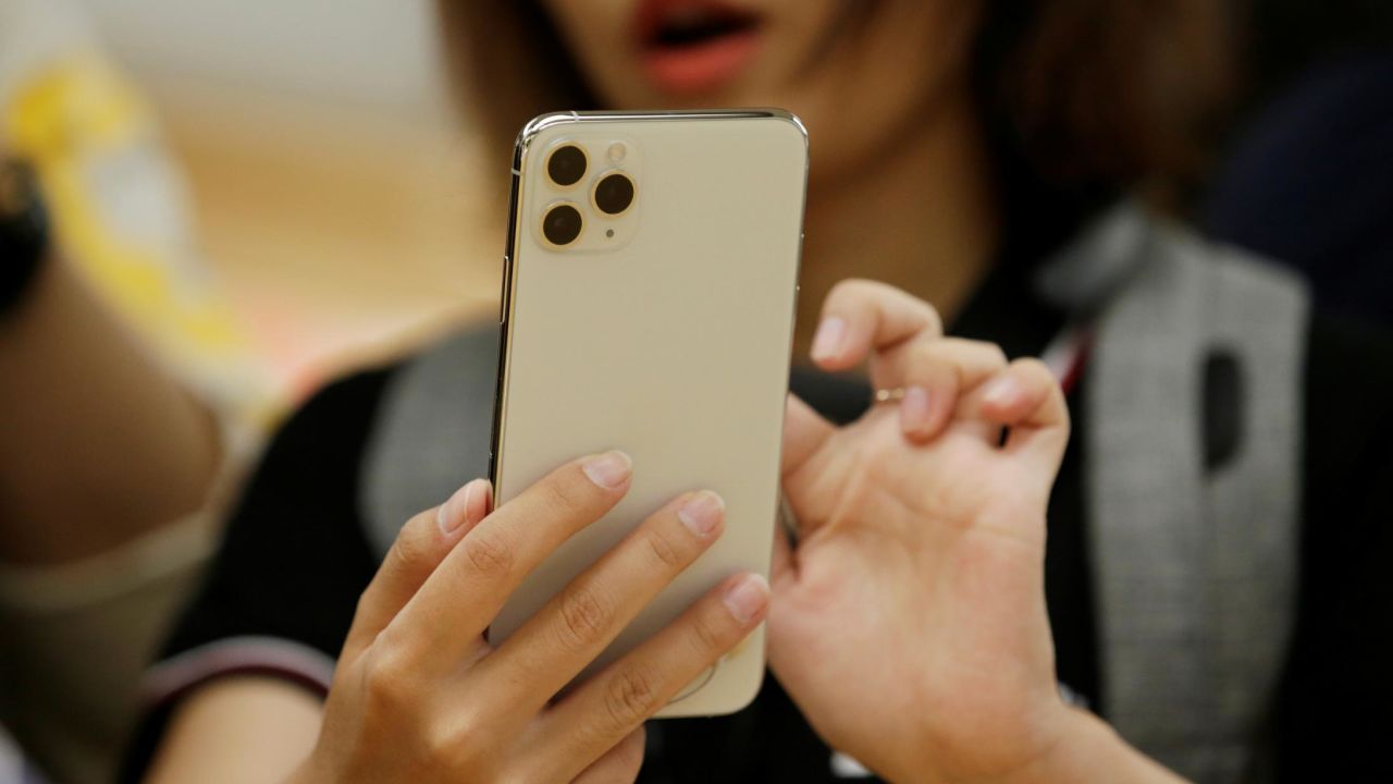 A woman holds an iPhone 11 Pro Max while giving a live broadcast after it went on sale at the Apple Store in Beijing, China, on September 20, 2019.