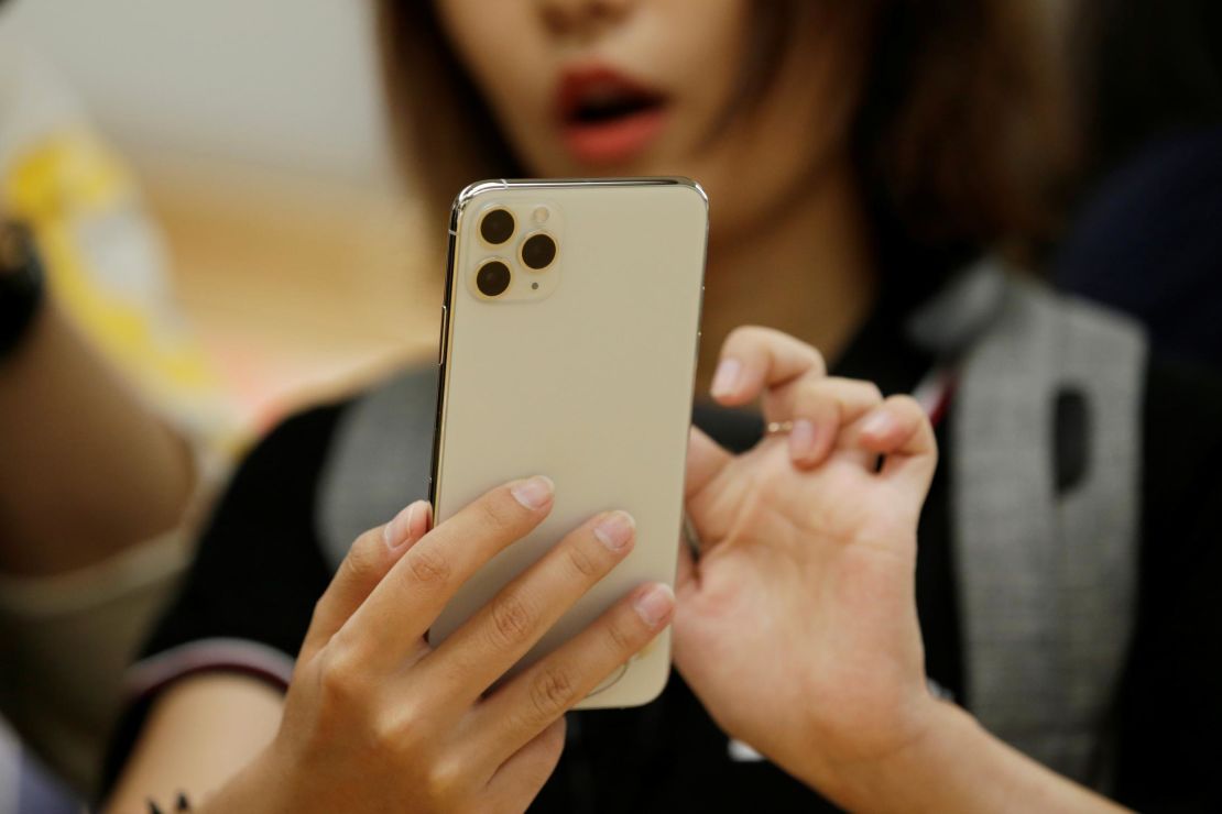 A woman holds an iPhone 11 Pro Max while giving a live broadcast after it went on sale at the Apple Store in Beijing, China, on September 20, 2019.