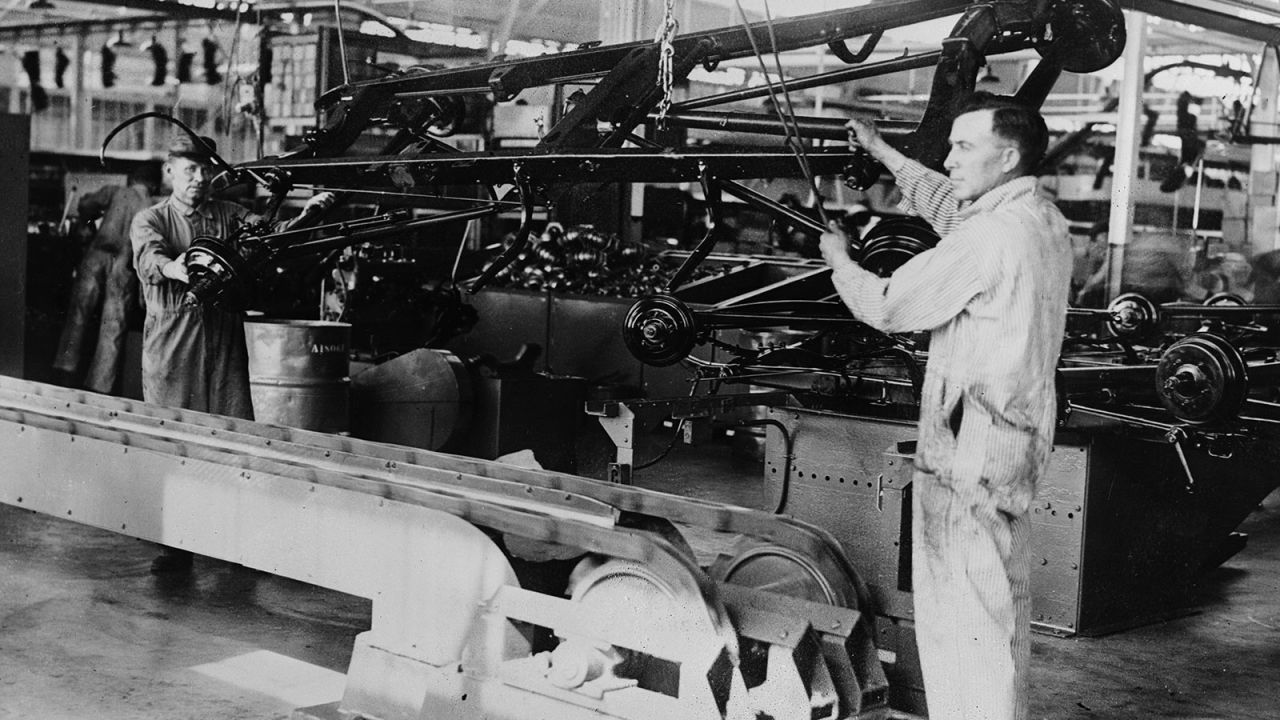 The first chassis on the assembly aisle at the Ford factory in Long Beach, California. In 1926, Ford Motor Company become one of the first employers to institute an eight-hour-a-day, five-day workweek.