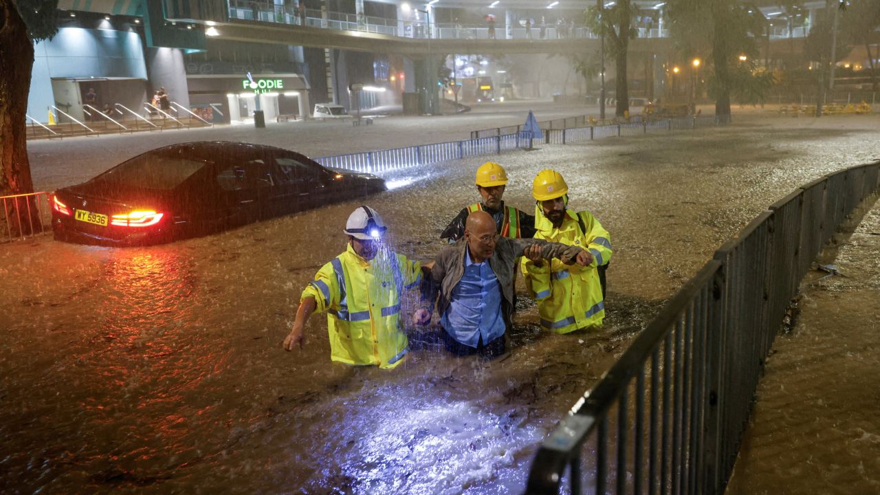 Drainage workers rescue a driver stranded due to flooding during heavy rain in Hong Kong on September 8, 2023.