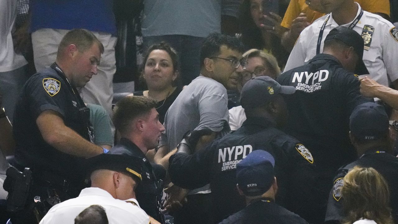 New York police officers escort a man out of the crowd.