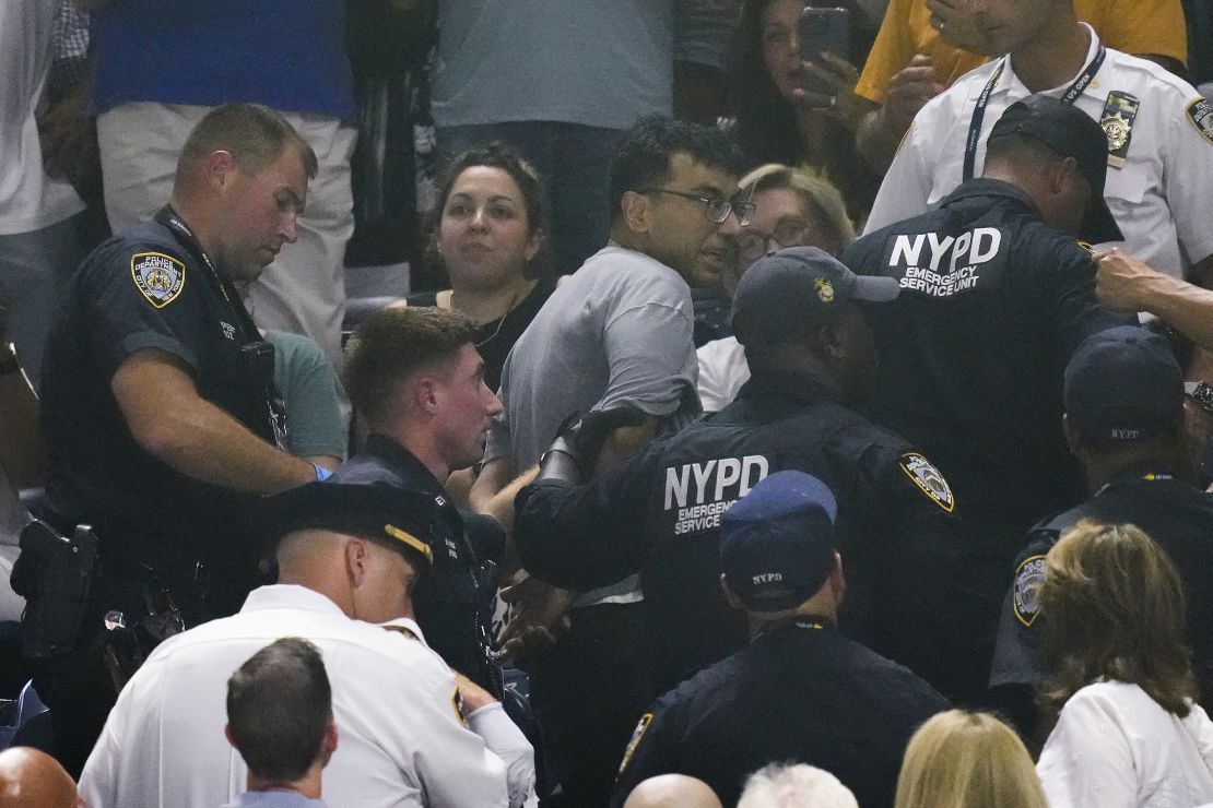 New York police officers escort a man out of the crowd.