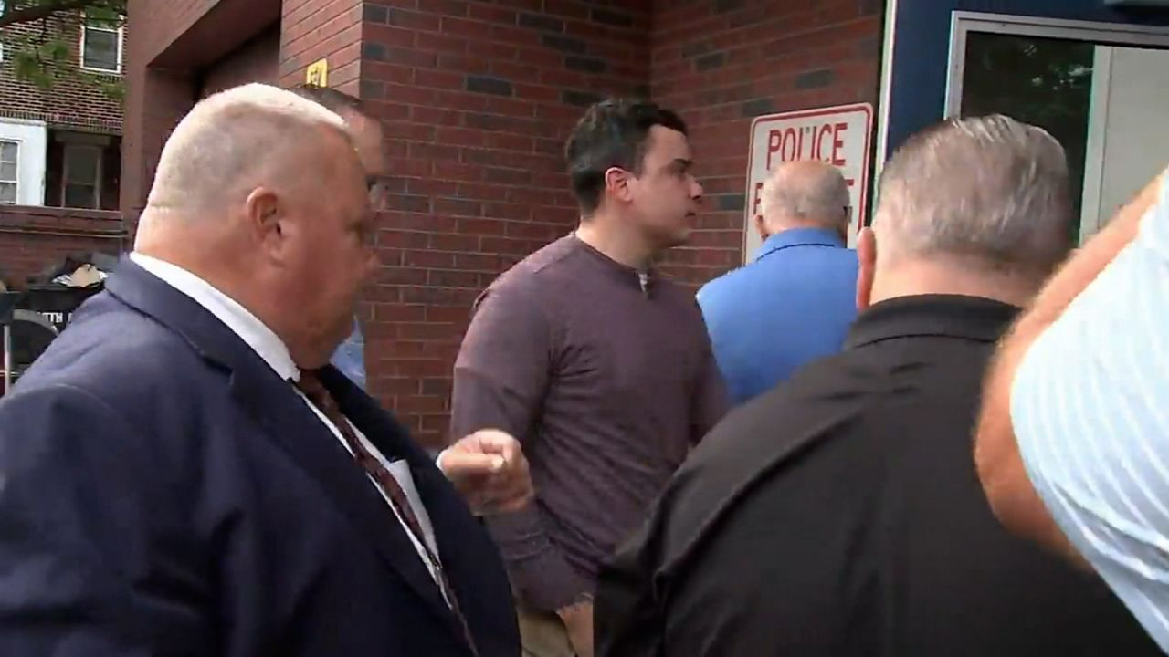 Philadelphia police Officer Mark Dial, center, turns himself in on a criminal warrant related to the fatal August shooting of Eddie Irizarry on September 8, 2023.