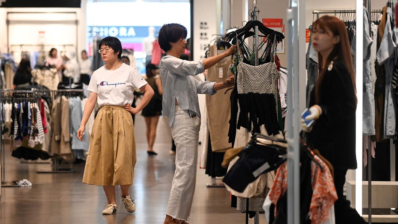 Một người phụ nữ đang chọn quần áo tại một trung tâm mua sắm ở Bắc Kinh vào ngày 15/6/2023.