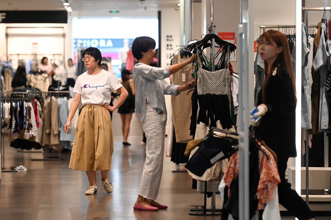 A woman selects clothes at a shopping mall in Beijing on June 15, 2023.