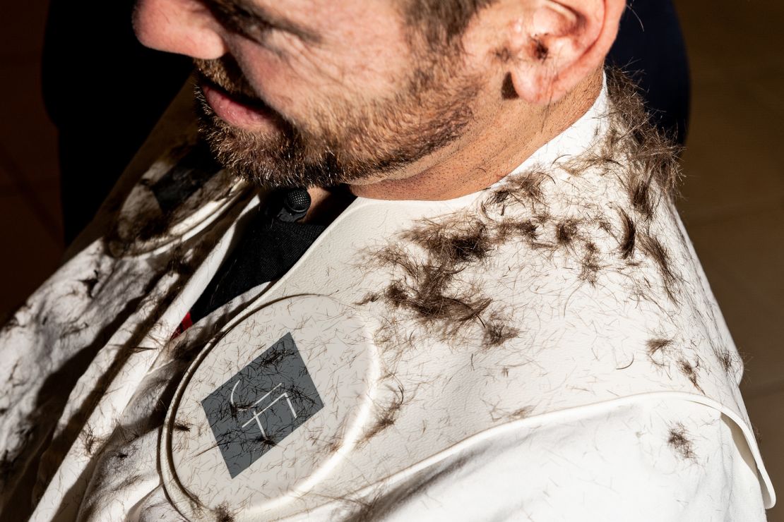 Hair clippings sit on the shoulders of tennis player Austin Krajicek while getting his hair cut by Julien Farel in Arthur Ashe stadium in Queens, New York, on Wednesday, August 30.