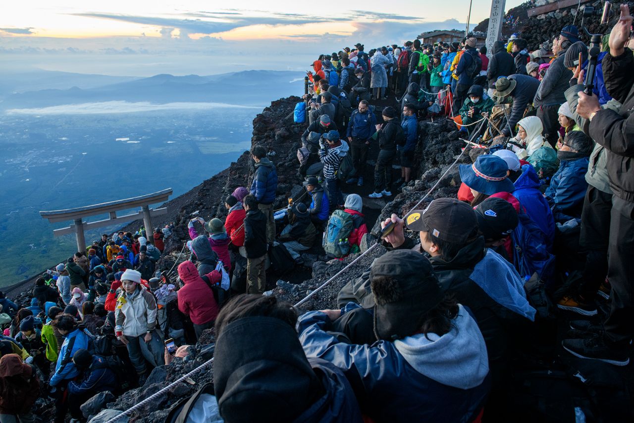 Crowds of tourists make their way to the summit of Mount Fuji to watch the sunrise.