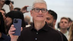 Apple CEO Tim Cook holds the new iPhone 14 at an Apple event at their headquarters in Cupertino, California, U.S. September 7, 2022. REUTERS/Carlos Barria
