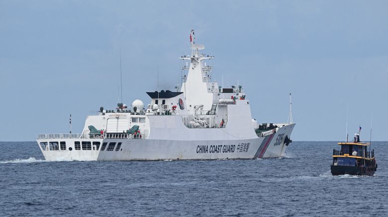 This photo taken on August 22, 2023 shows a Chinese coast guard ship (L) shadowing a Philippine civilian boat chartered by the Philippine navy to deliver supplies to Philippine navy ship BRP Sierra Madre in the disputed South China Sea.
