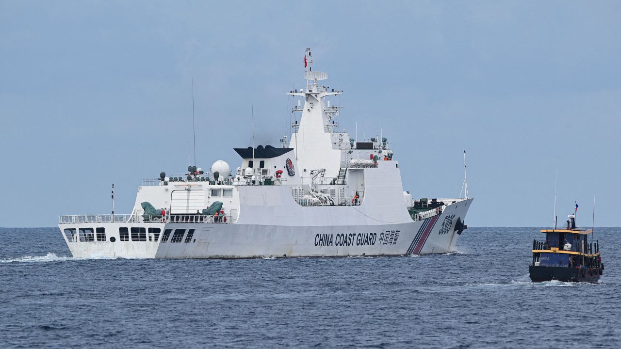 This photo taken on August 22, 2023 shows a Chinese coast guard ship (L) shadowing a Philippine civilian boat chartered by the Philippine navy to deliver supplies to Philippine navy ship BRP Sierra Madre in the disputed South China Sea