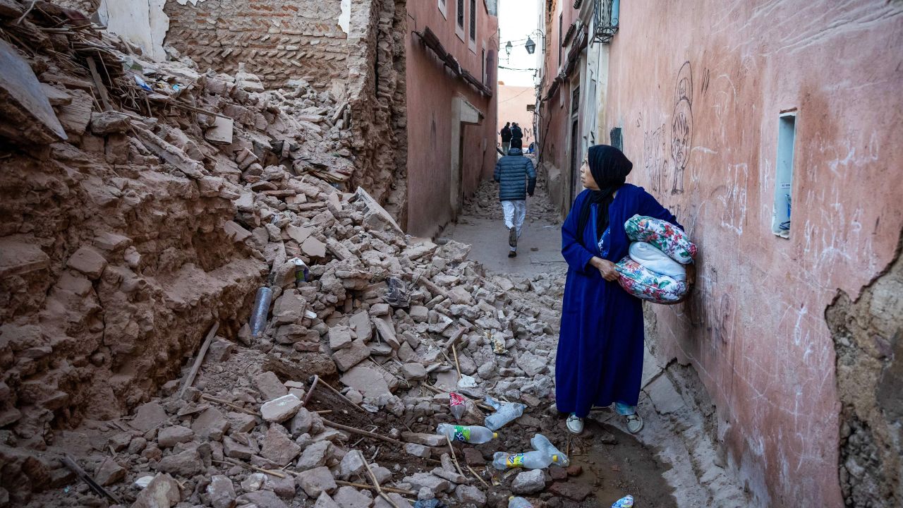 A woman stands among the rubble of a building in the earthquake-damaged old city of Marrakech.