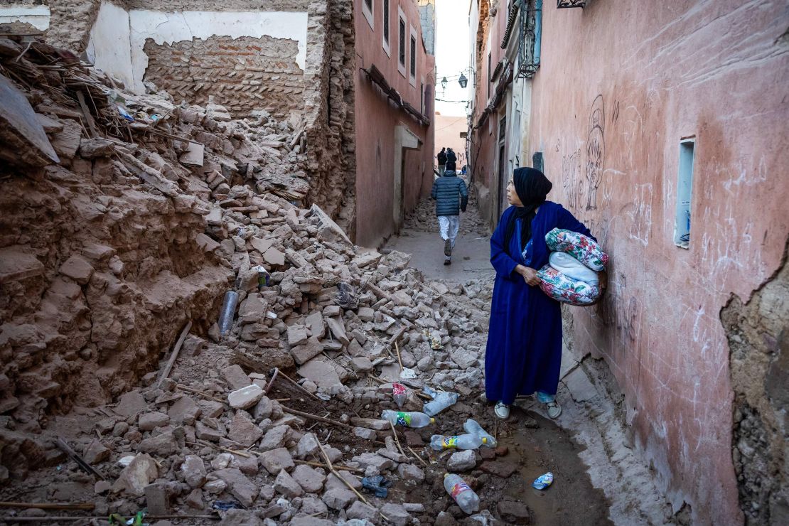 A woman stands among the rubble of a building in the earthquake-damaged old city of Marrakech.