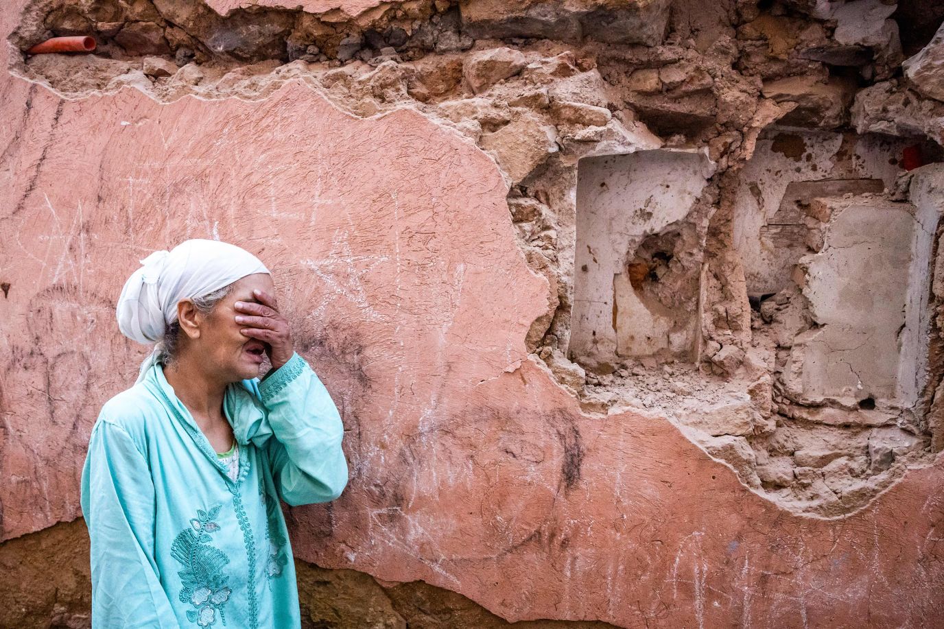 A woman stands in front of her earthquake-damaged house in Marrakech, Morocco on September 9. <br />