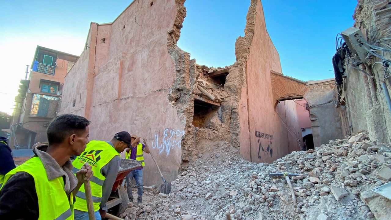  Хората работят близо до щетите в историческия град Маракеш след земетресението.“ class=