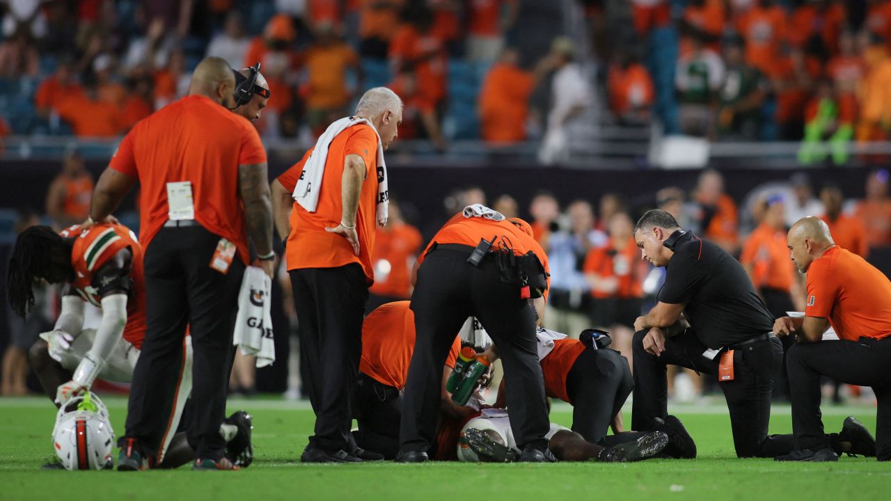 Miami Hurricanes head coach Mario Cristobal looks on as trainers check on Miami Hurricanes safety Kamren Kinchens (5) after an injury. 