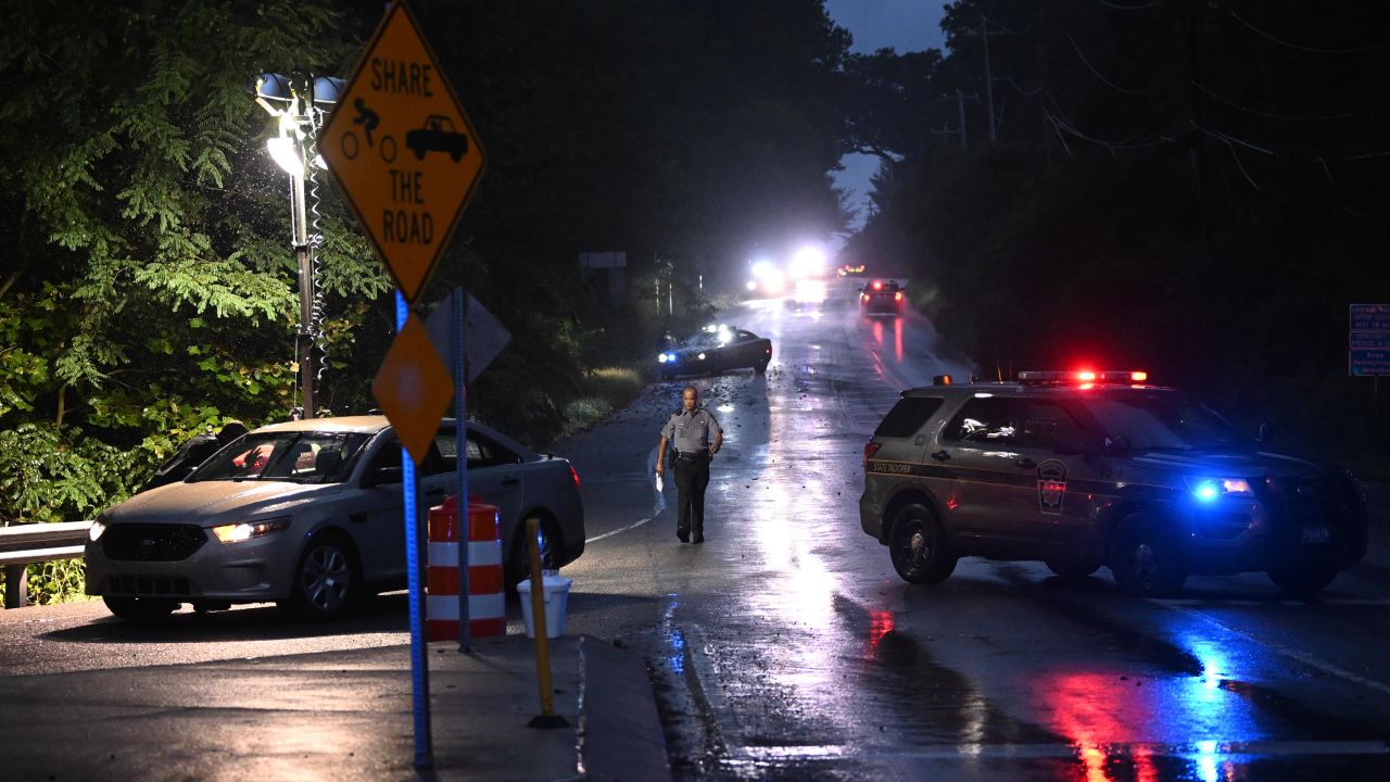 Police monitor a wooded perimeter in the rain during a manhunt for convicted murderer Danelo Cavalcante in Kennett Square, Pennsylvania, on Saturday.