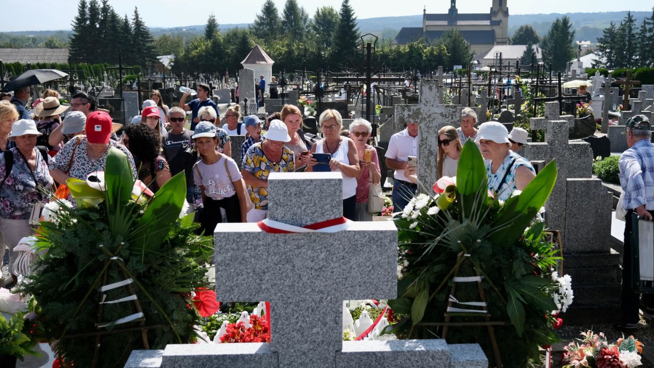 People stand at the family grave of the Ulma family, who Pope Francis described as a 