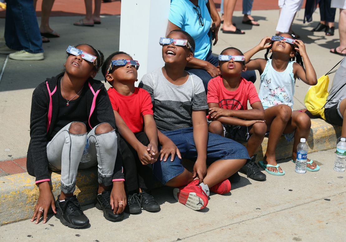 GARDEN CITY, NY - 21 AUGUST: Vizitatorii privesc spre cer în timpul unei eclipse parțiale de soare la Muzeul Cradle of Aviation pe 21 august 2017 în Garden City, New York.  Milioane de oameni sunt concentrați în zonele din Statele Unite 