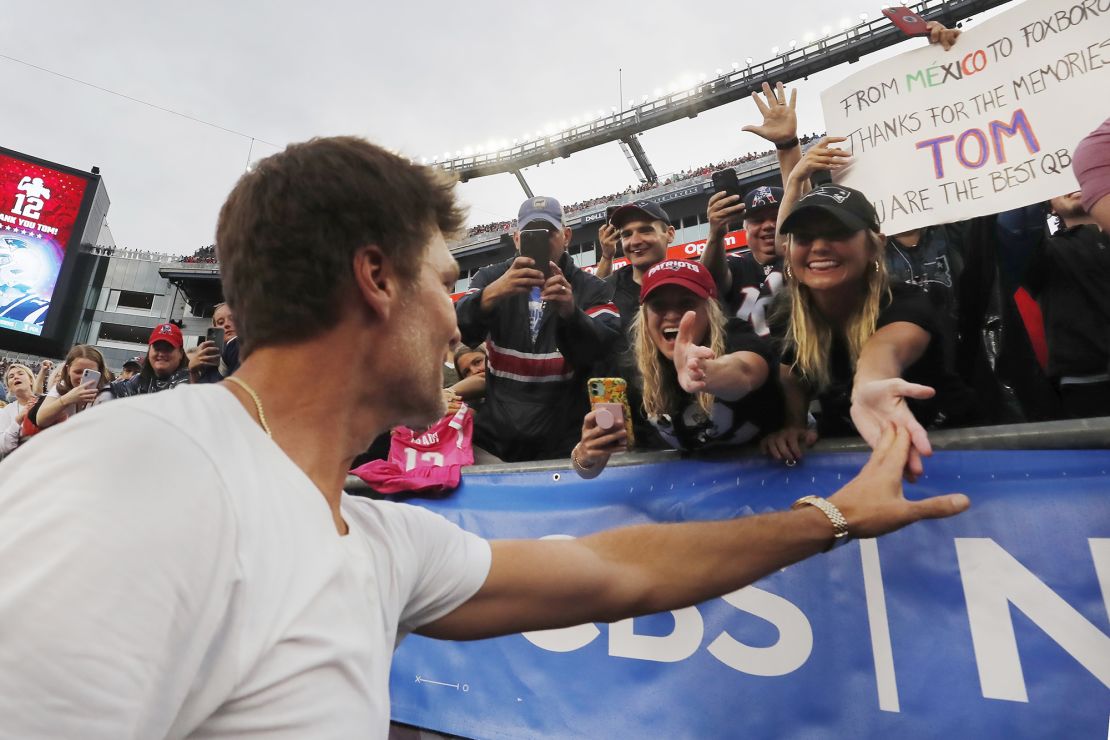 Former New England Patriots' Tom Brady reaches out to fans following a ceremony in his honor during halftime of an NFL football game between the Philadelphia Eagles and the New England Patriots, Sunday, Sept. 10, 2023, in Foxborough, Mass. (AP Photo/Michael Dwyer)