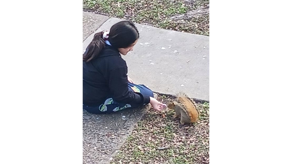 Amethyst Sistine Silva feeds a squirrel she befriended.