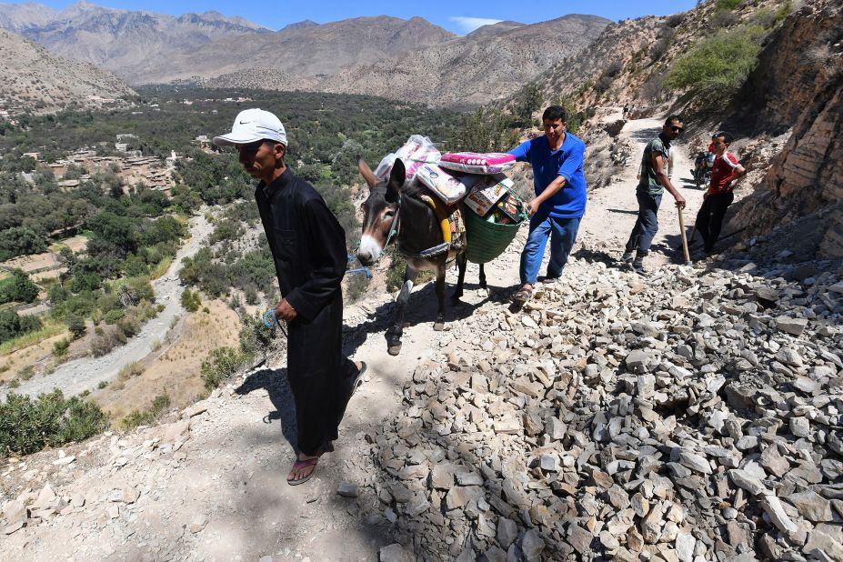 Men transport supplies on the back of a donkey as they travel to the village of Imoulas on September 11.