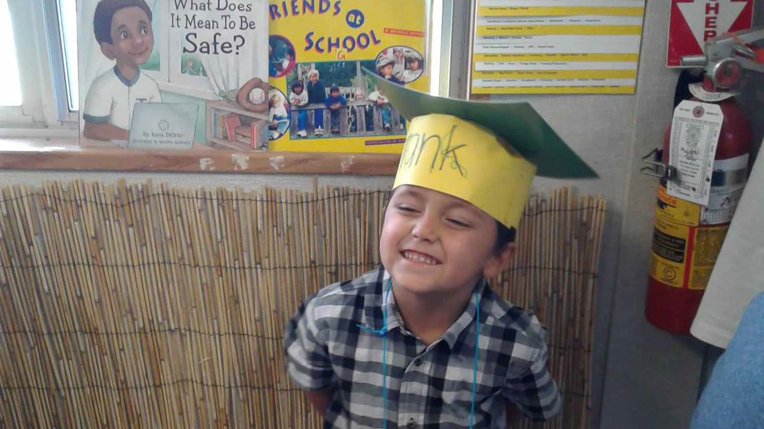 Frankie grins during his preschool graduation, celebrating with a hat he made himself.