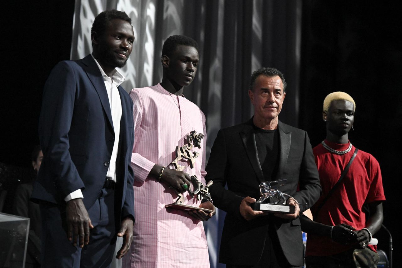 Mamadou Kouassi (L), actor Seydou Sarr and actor Moustapha Fall (R) stand next to Italian director Matteo Garrone as he received the Silver Lion for Best Director for 'Io Capitano' during the award ceremony of the 80th Venice Film Festival on September 9, 2023 at Venice Lido. (Photo by Tiziana FABI / AFP) (Photo by TIZIANA FABI/AFP via Getty Images)