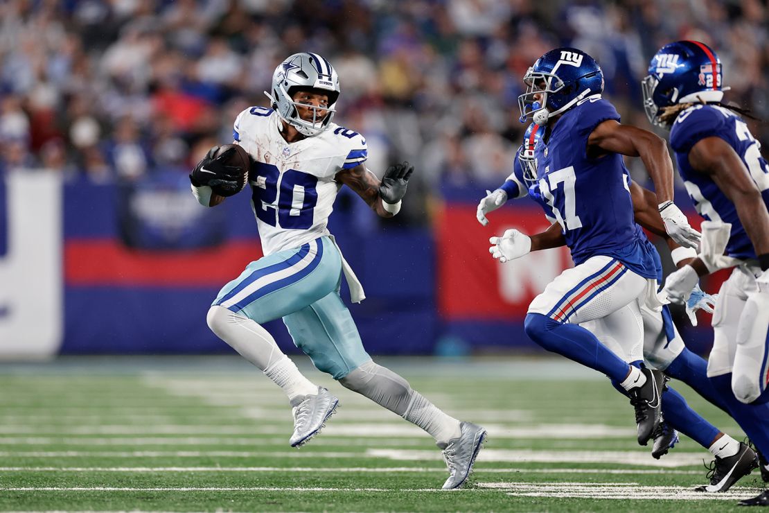 Dallas Cowboys' Tony Pollard, left, runs the ball during the second half of an NFL football game against the New York Giants, Sunday, Sept. 10, 2023, in East Rutherford, N.J.