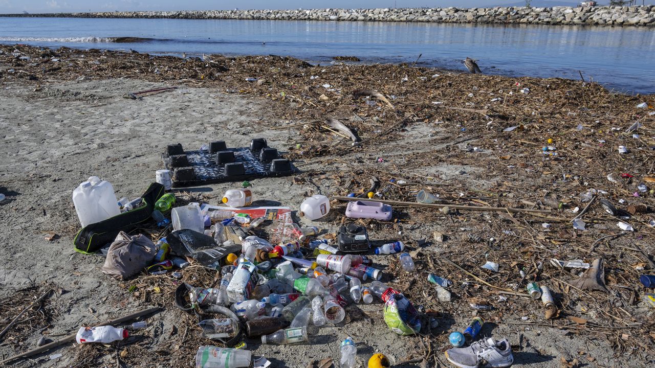 Trash piles up along the bank of the San Gabriel River near the Pacific Ocean in Seal Beach, California. Rains sent the trash flowing down river from miles inland.