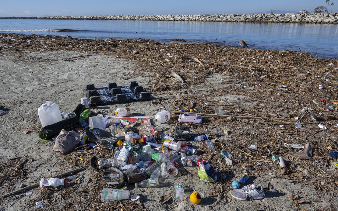 Trash piles up along the bank of the San Gabriel River near the Pacific Ocean in Seal Beach, California. Rains sent the trash flowing down river from miles inland.