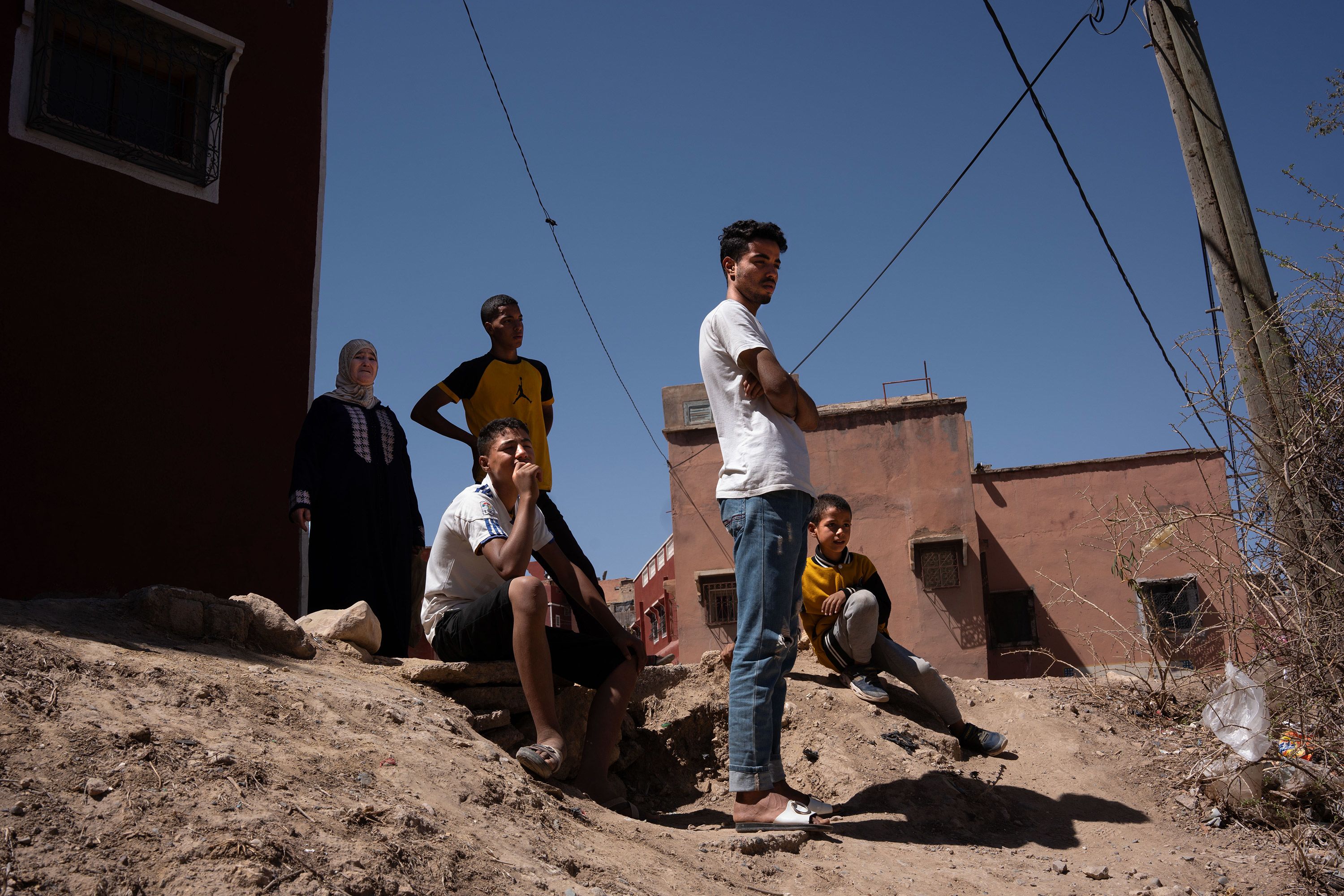Relatives and neighbors of Lhssan Asoki look at the destroyed house where Asoki's wife and his three children died in Moulay Brahim, Morocco.