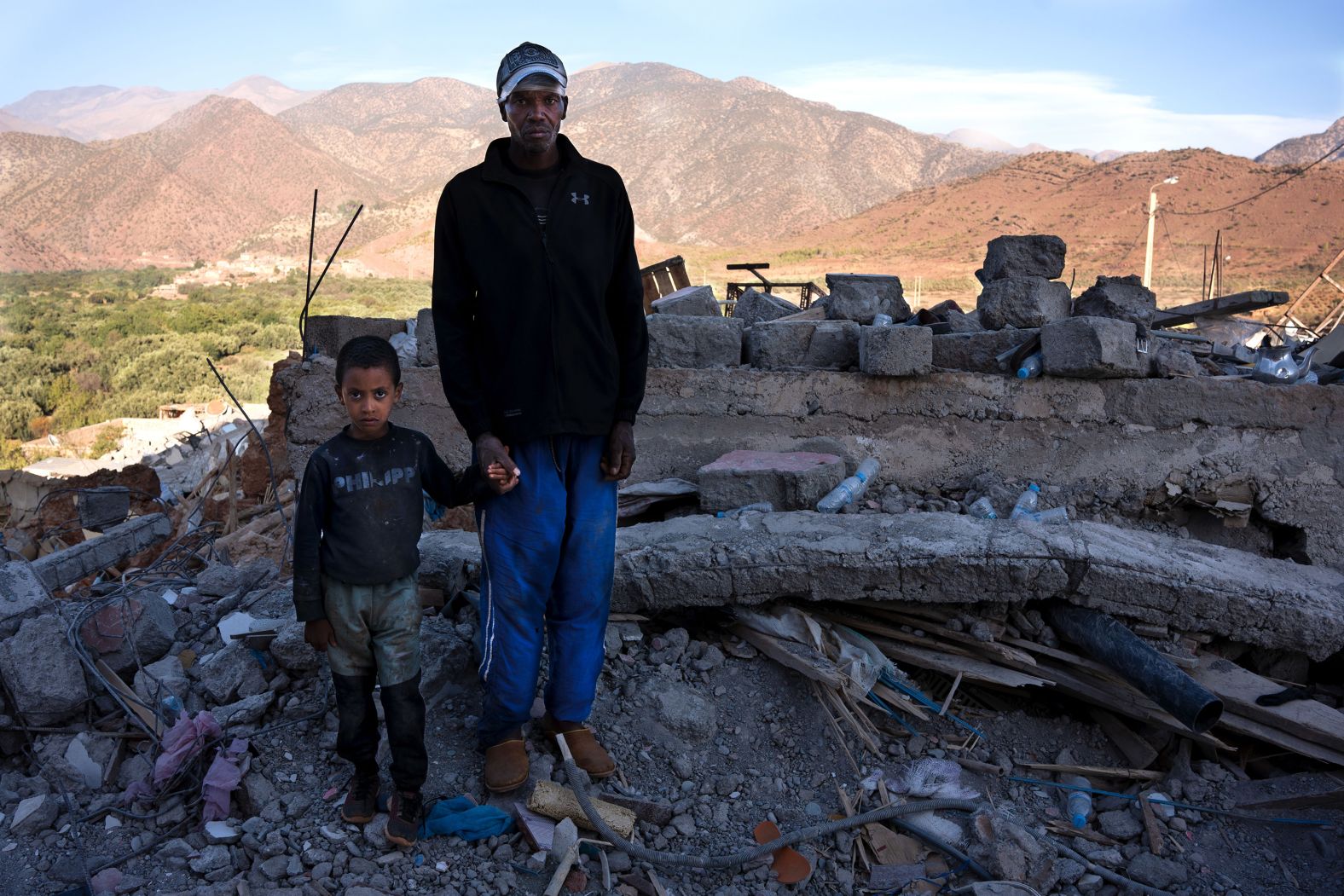 Jamal and his son stand where their house used to be in Idni. They spent nearly 24 hours under the rubble until they were rescued. Jamal lost his parents, however, and his uncle, Borrazás said.