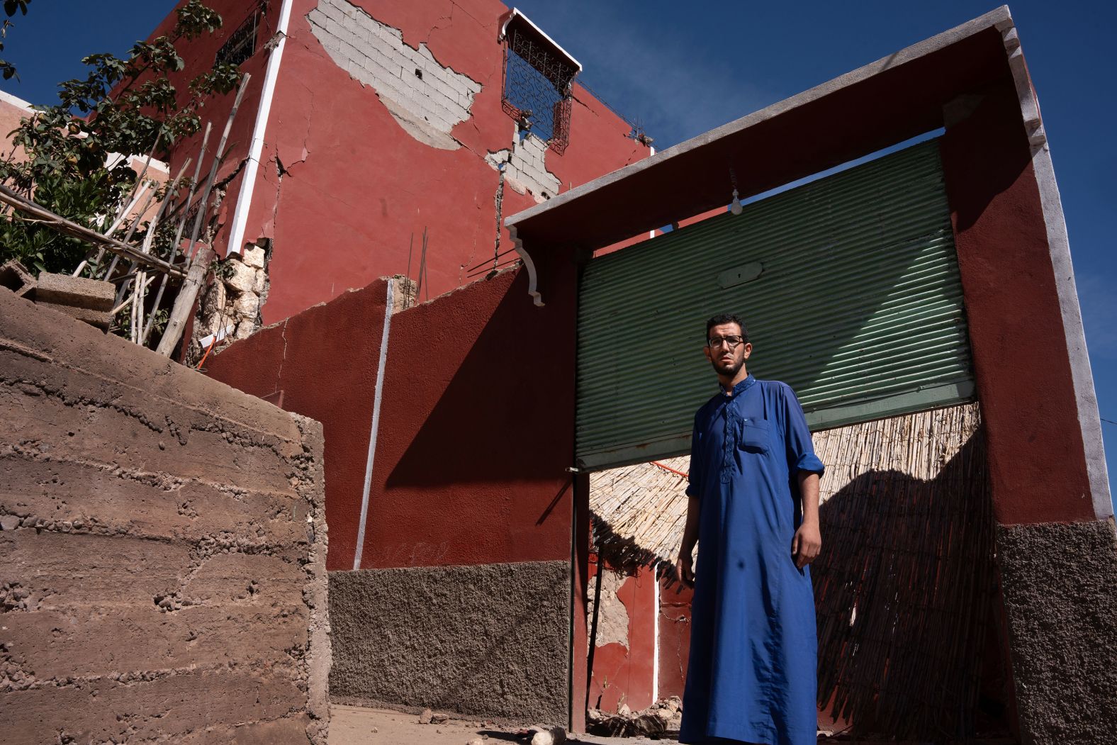 Yassine Nomghar poses in front of his destroyed house in Moulay Brahim. "My father built this house in the 1980s, and little by little we all added more parts with a lot of effort," he said. "Now we don't have anything."