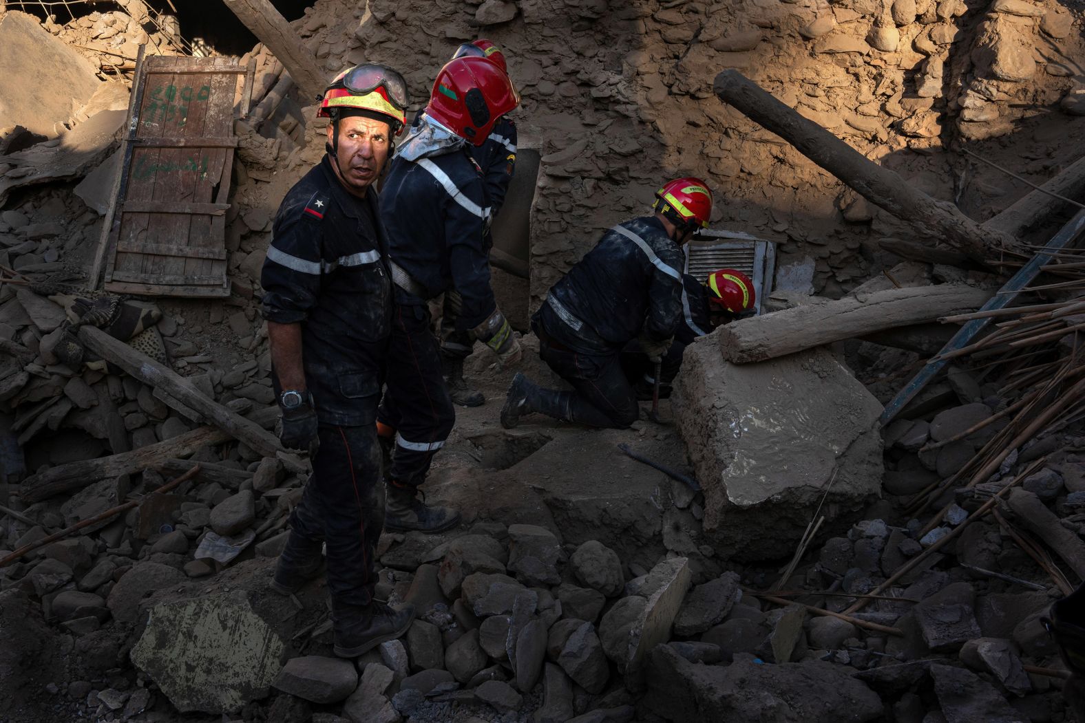 Firefighters work to remove the bodies of people who were crushed to death when a cafe collapsed in Amizmiz.