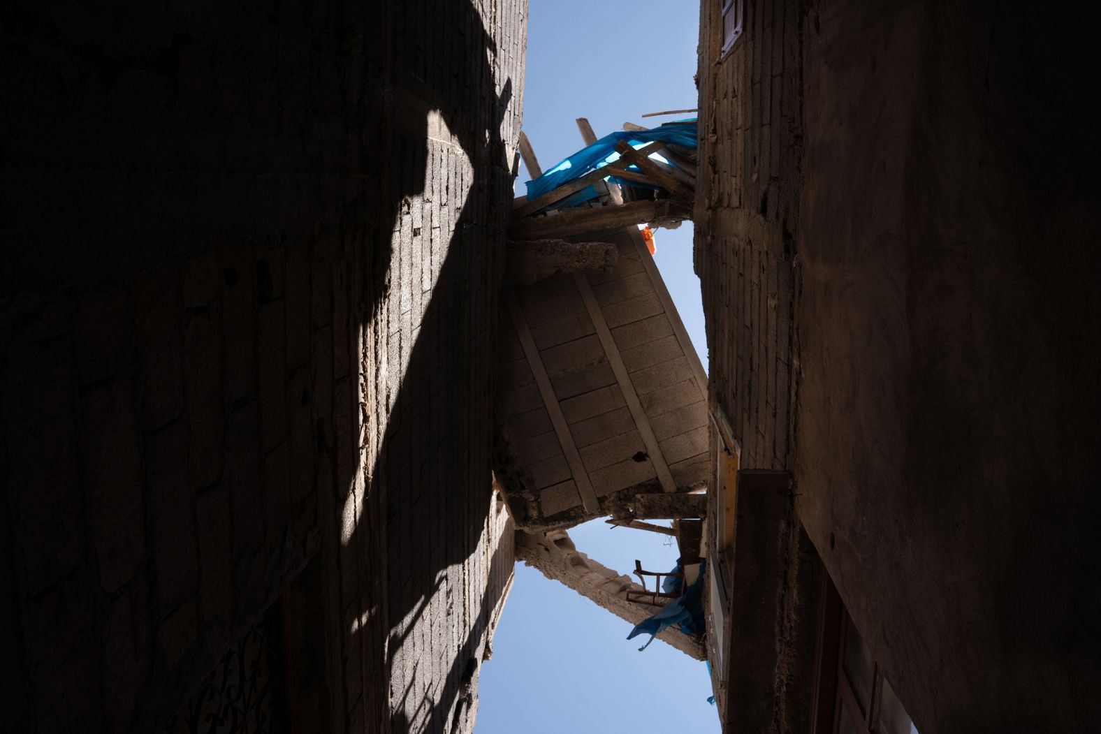 A piece of a collapsed house hangs over a corridor in Amizmiz.