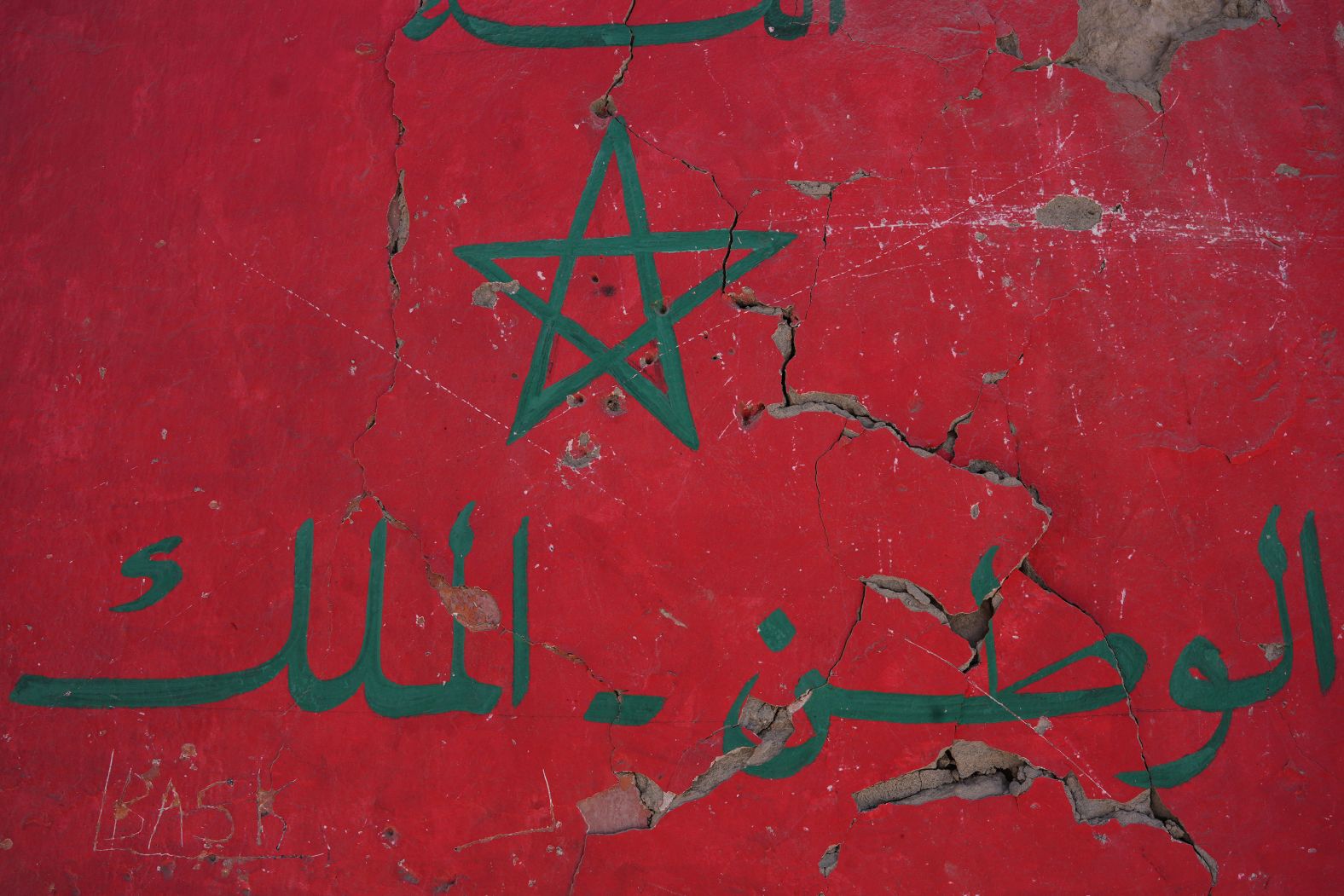 A painting of the Moroccan flag with Arabic inscriptions is seen on a house destroyed in Amizmiz.
