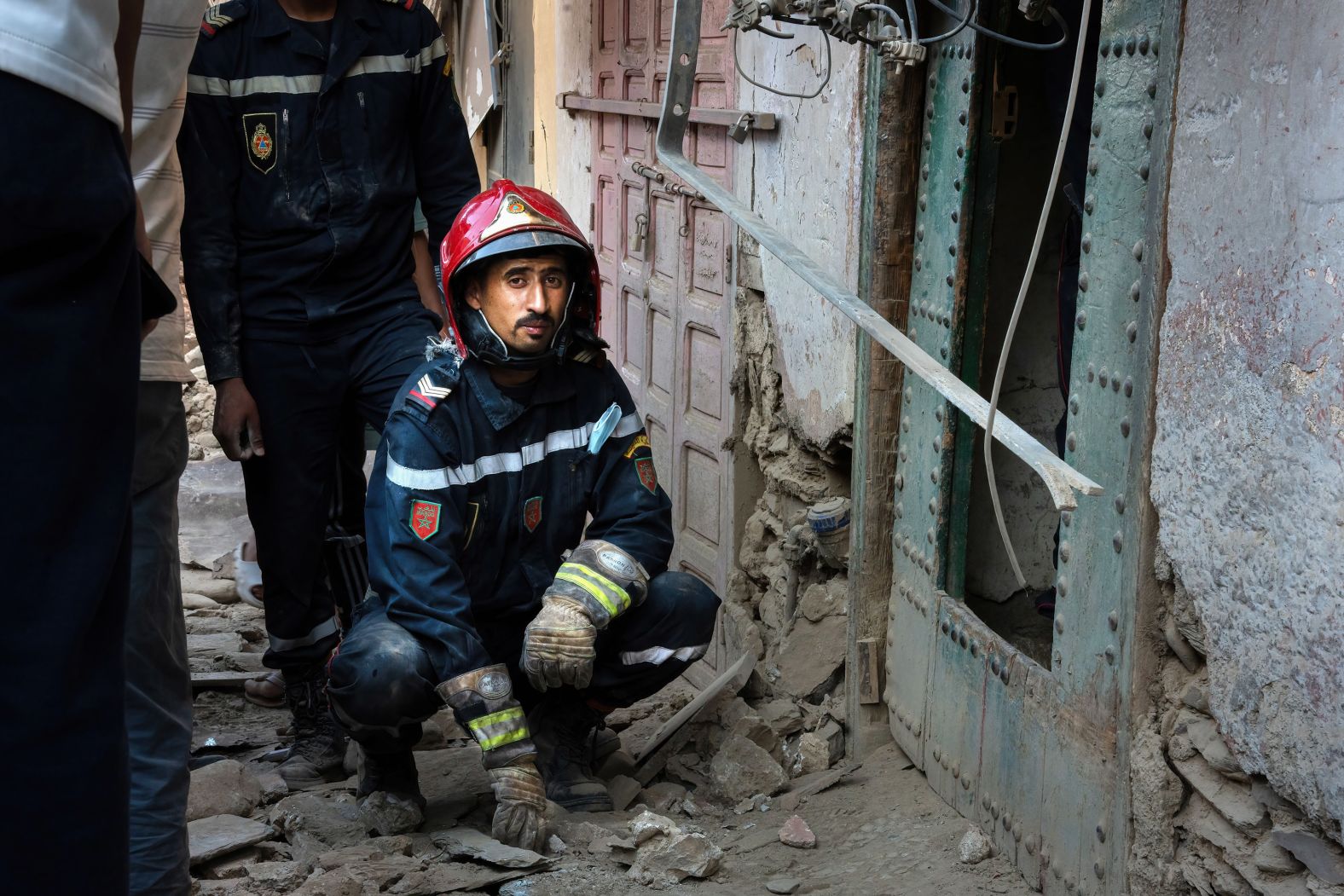 A firefighter rests outside a collapsed house while searching for bodies in Amizmiz.