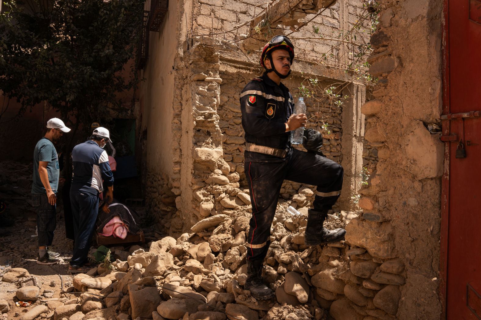 A firefighter drinks water in Amizmiz after the 84-year-old woman's body was pulled from the rubble.