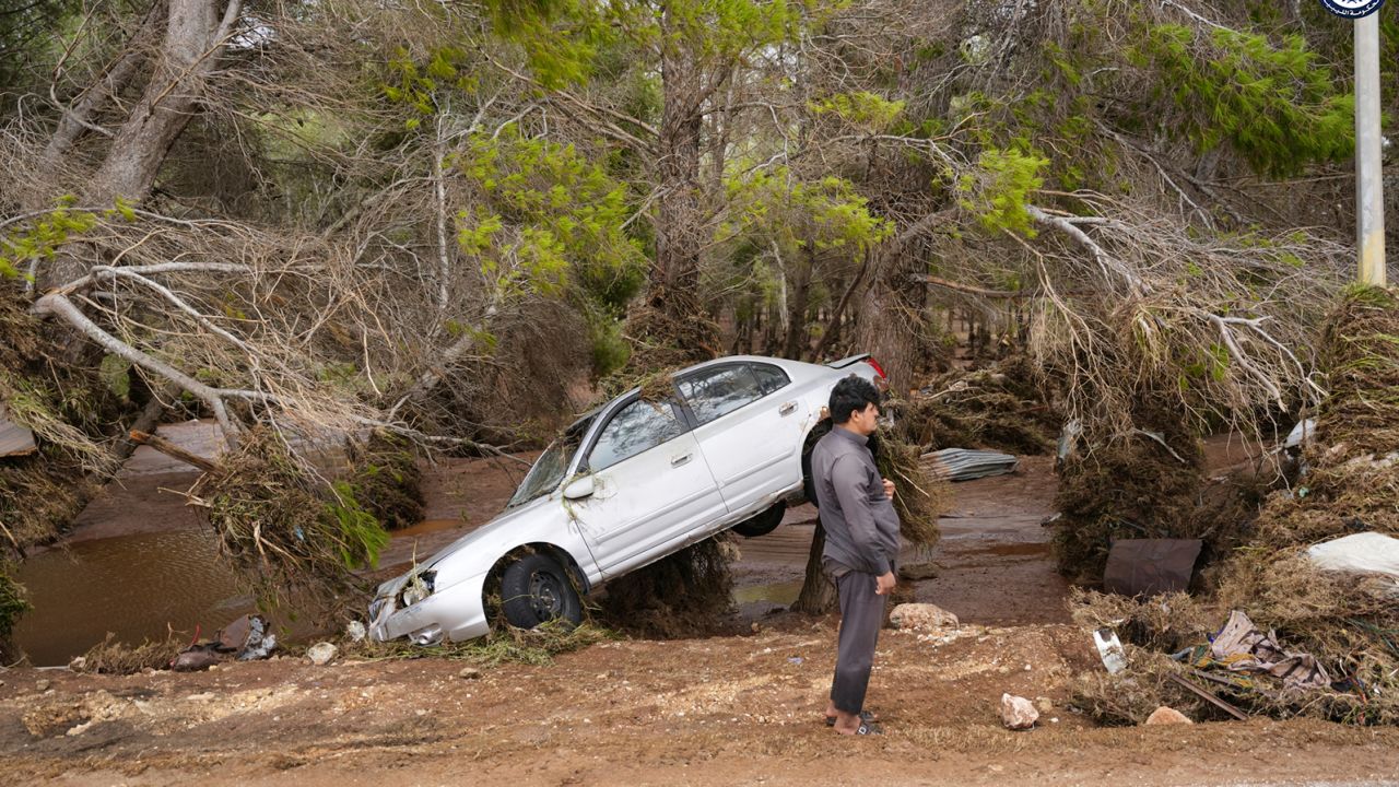 A car is partly suspended from trees after being carried by floodwaters in Derna, Libya, on Monday, Sept. 11, 2023.