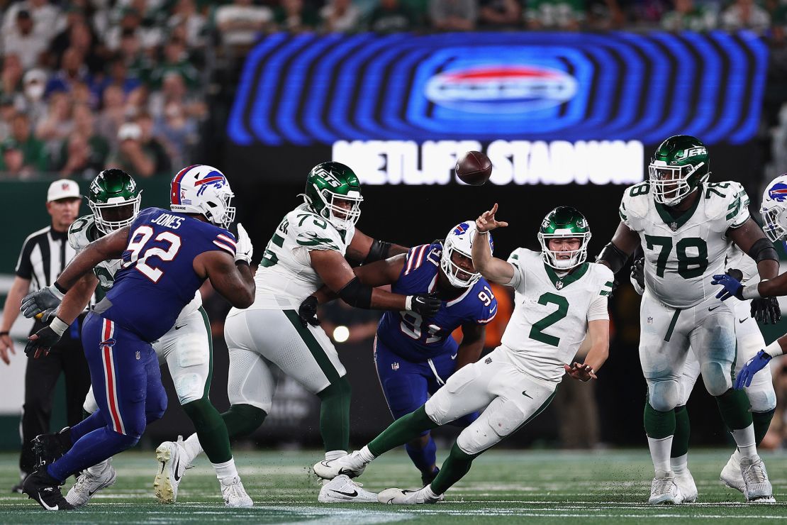 Quarterback Zach Wilson throws a pass under pressure from the Bills' pass rush.